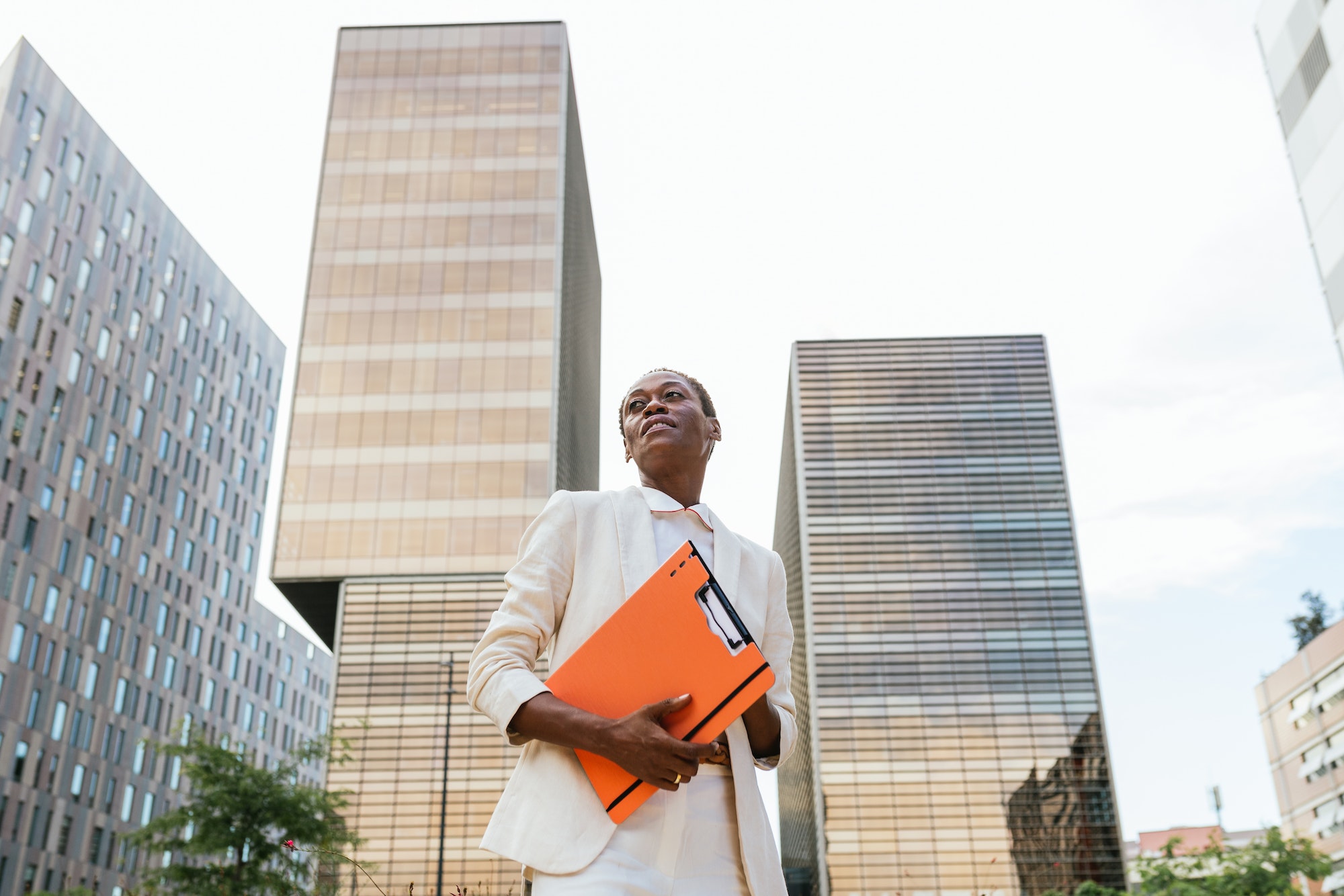 Empowered African Businesswoman with Orange Folder in Urban Business District